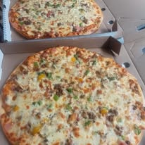 Two cheesy pizzas in boxes